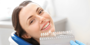 woman smiling next to teeth whitening comparison kit